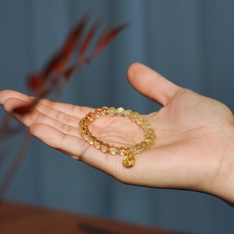 Sparkling citrine bracelet with a gold charm, crafted to attract joy and prosperity.