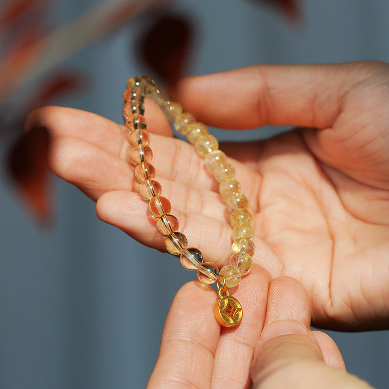 Sparkling citrine bracelet with a gold charm, crafted to attract joy and prosperity.