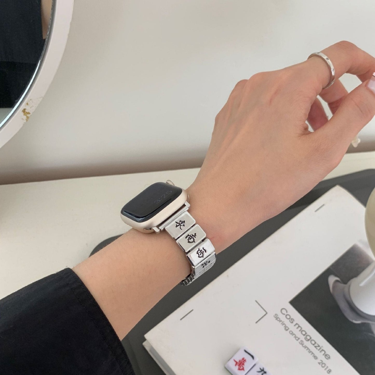 Silver Mahjong Apple Watch band worn on a wrist, with white accents and a minimalist setup