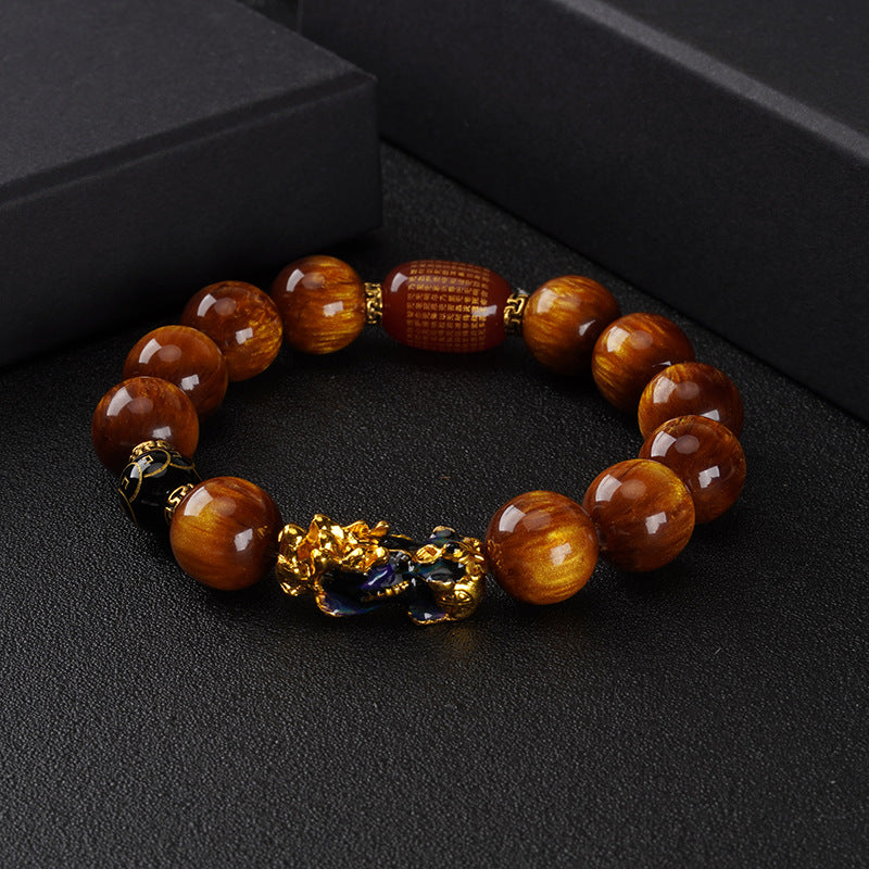 Rich brown Tiger’s Eye beads with a golden Pi Xiu charm, believed to attract wealth and protection.