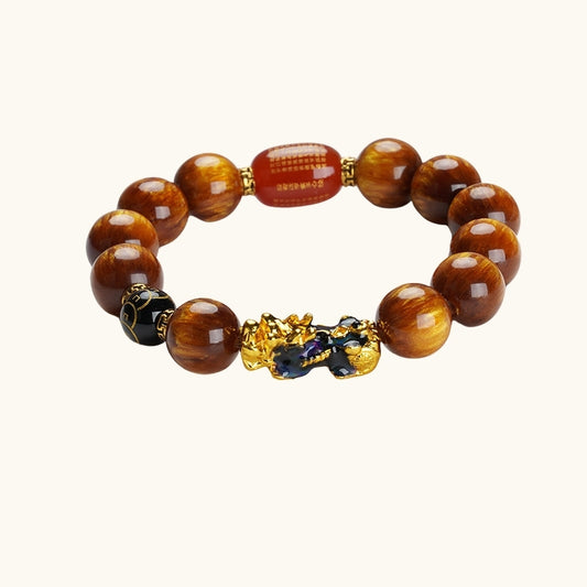 Rich brown Tiger’s Eye beads with a golden Pi Xiu charm, believed to attract wealth and protection.